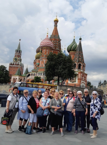 A group of thirteen women posing for a photo in Red Square